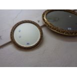 A small ornate gilt framed bevelled circular wall mirror