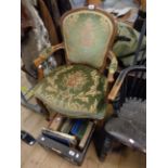 A reproduction stained beech framed elbow chair with green floral upholstery, set on cabriole legs