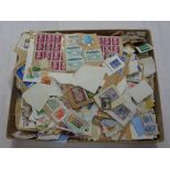 A box containing a collection of used world postage stamps on paper