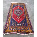 A modern handmade rug with central medallion surrounded by floral motifs and border decorated with