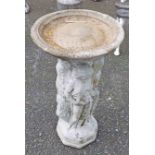 A concrete garden bird bath in the form of four classical maidens with circular bath