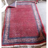 A modern handmade rug decorated with close repeat flower motif and decorated border on a red and