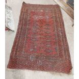 An old Turkish rug with repeat geometric and star motifs and a triple panel border on burgundy