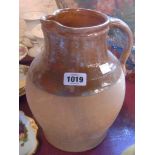 A large antique terracotta part glazed milk jug