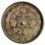 An antique Chinese cast bronze hand mirror decorated with cranes and blossom with a central shield