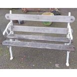 An old garden bench with cast iron branch form ends and slatted wooden seat and back