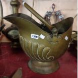 An old brass coal scuttle of helmet form with embossed decoration