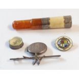 A bag containing a white metal locket, miniature compass and a cheroot holder, etc.