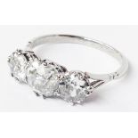 A high carat white metal ring, set with three large brilliant cut diamonds
