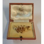 A 9ct. / 375 ornate gold stylised foliate pattern brooch, set with orange topaz and seed pearls - in