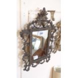 A small vintage cast metal framed oblong wall mirror with bronzed finish and scroll decoration