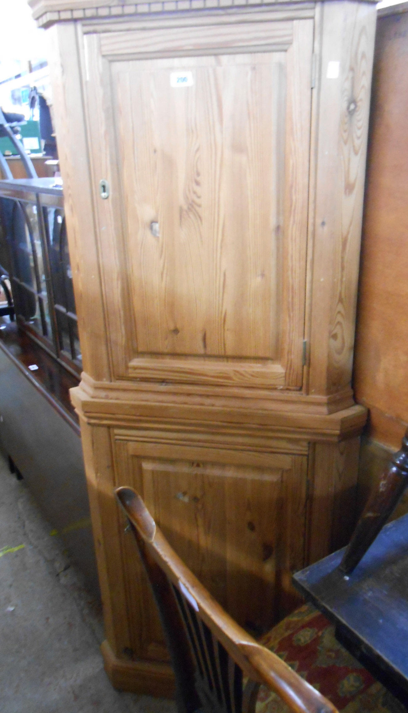A 20th Century two part pitch pine corner cupboard, the upper cupboard with dentil cornice, each