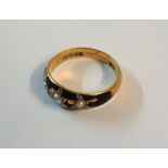 An 18ct. gold mourning ring with black enamelled band and three gypsy set pearls - internal