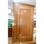 A 62cm oak wall hanging corner cupboard with scalloped shelves enclosed by a panelled door