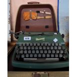 A vintage Rheinmetall portable typewriter in original case with green textured finish and cleaning