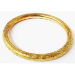 A marked 585 (14ct) engraved yellow metal bangle