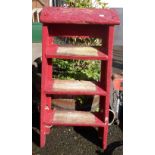 A set of small wooden step ladders with later red painted finish