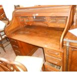 A 1.25m early 20th Century oak roll-top desk with tambour enclosing a fitted interior, flanking