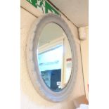 A grey painted wood framed bevelled oval wall mirror
