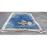 A large handmade rug with dragon and bamboo decoration on blue ground