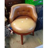 A late 20th Century stained wood framed swivel chair with studded button back leather upholstery