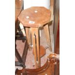 An old two-tier plant stand with octagonal surfaces and pierced decoration to legs