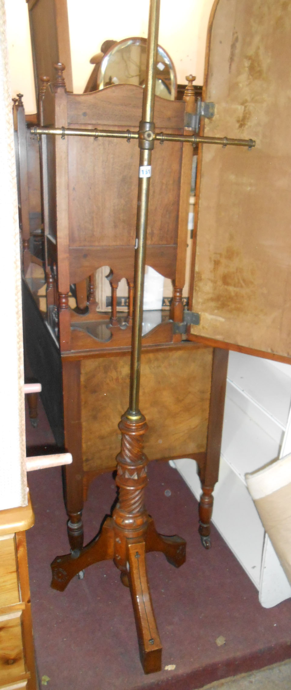 A Victorian stained oak and brass pole screen with cross rail and carved decoration to tripod base