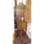 A Victorian stained oak and brass pole screen with cross rail and carved decoration to tripod base