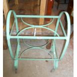 A vintage green painted wrought iron two tier tea trolley, set on casters - glass inserts missing