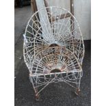 An old wirework garden chair with scroll and fan decoration set on scroll feet