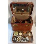 A leather vanity case containing watch chains, costume jewellery and other items