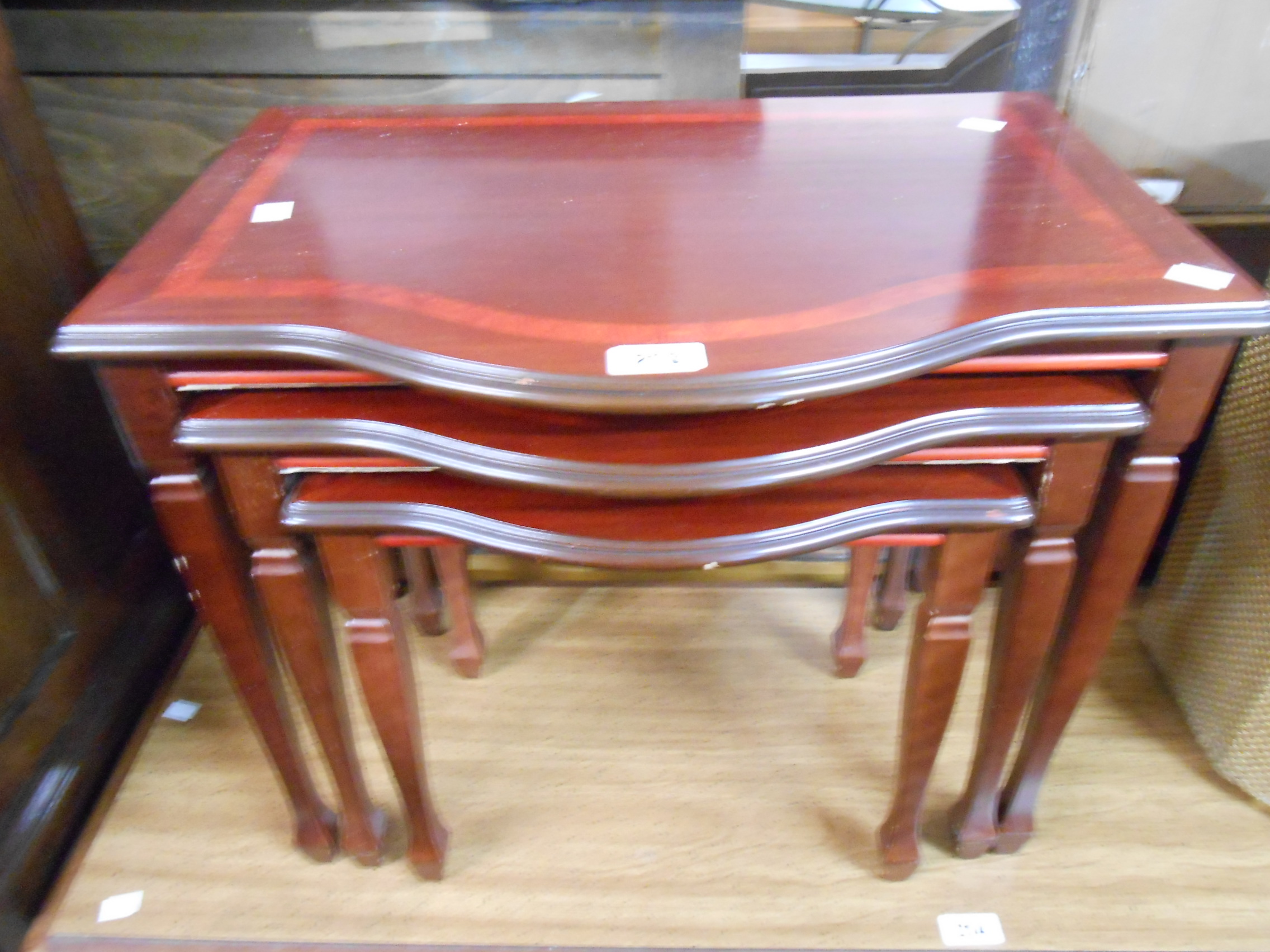 A reproduction mahogany nest of three break bow front tea tables