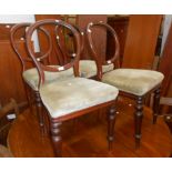 A set of four Victorian mahogany framed balloon back dining chairs with overstuffed upholstered