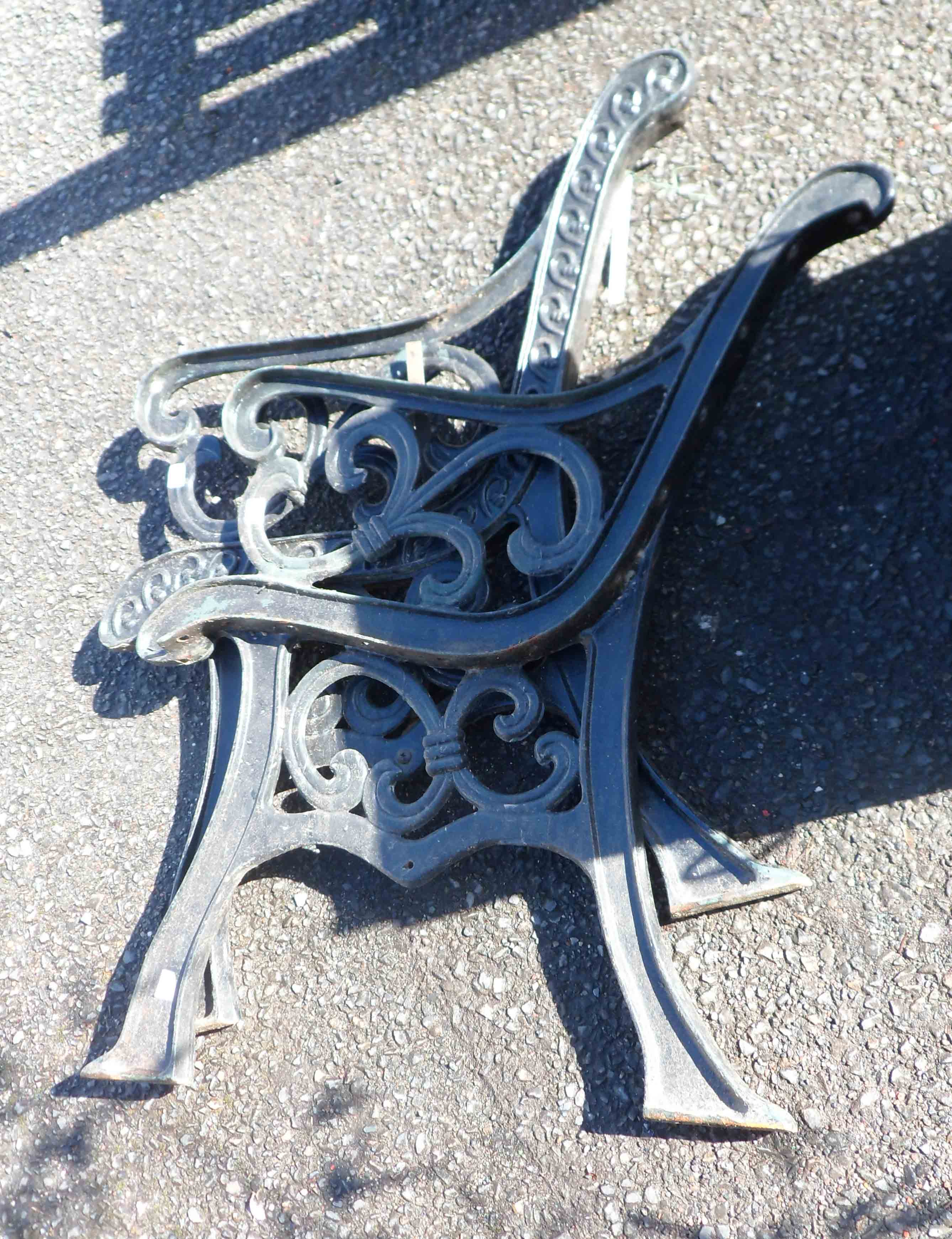 A pair of modern painted cast iron bench ends