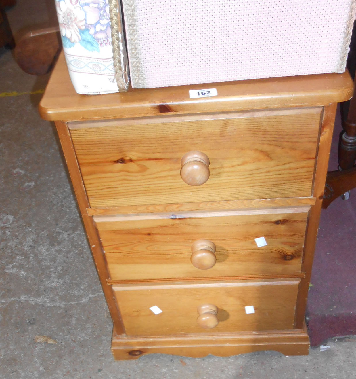 A modern pine bedside chest of three drawers