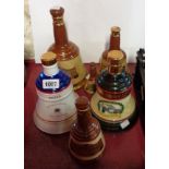 Six Wade porcelain Bells Whisky decanters of various size and design