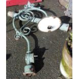 An old outside electric lamp with cast iron pillar and wrought iron bracket with scrolling
