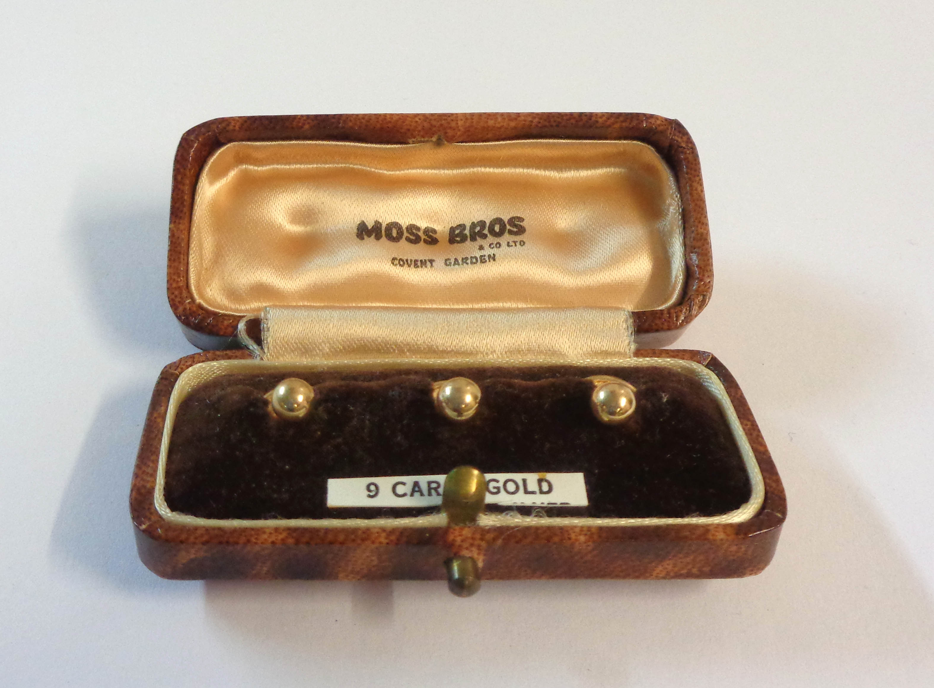 A cased set of three Moss Bros 9ct. gold studs