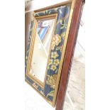 A modern painted wood framed bevelled oblong wall mirror with all over floral and gilt decoration