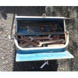 A vintage metal toolbox containing a large quantity of spanners