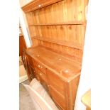 A 1.5m 20th Century waxed pine two part dresser with two shelf open plate rack over a base with