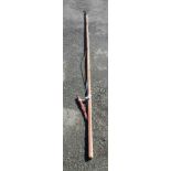 An old tree lopper with long wooden body and metal lopper end and handle