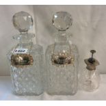 A pair of cut glass decanters with faceted stoppers and silver Whisky and Brandy labels - sold