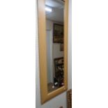 A modern oak effect framed narrow oblong wall mirror