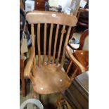 An old stained mixed wood high lathe back elbow chair with moulded solid elm seat, set on turned