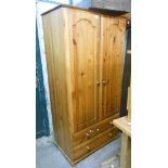 An 89cm modern pine double wardrobe with hanging space and two long drawers under, set on bun feet