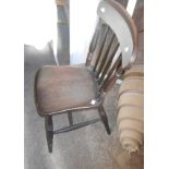 An antique stained wood stick back kitchen chair with moulded solid elm seat, set on ring turned