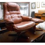 A modern brown leather upholstered swivel easy chair and a foot stool to match, both set on