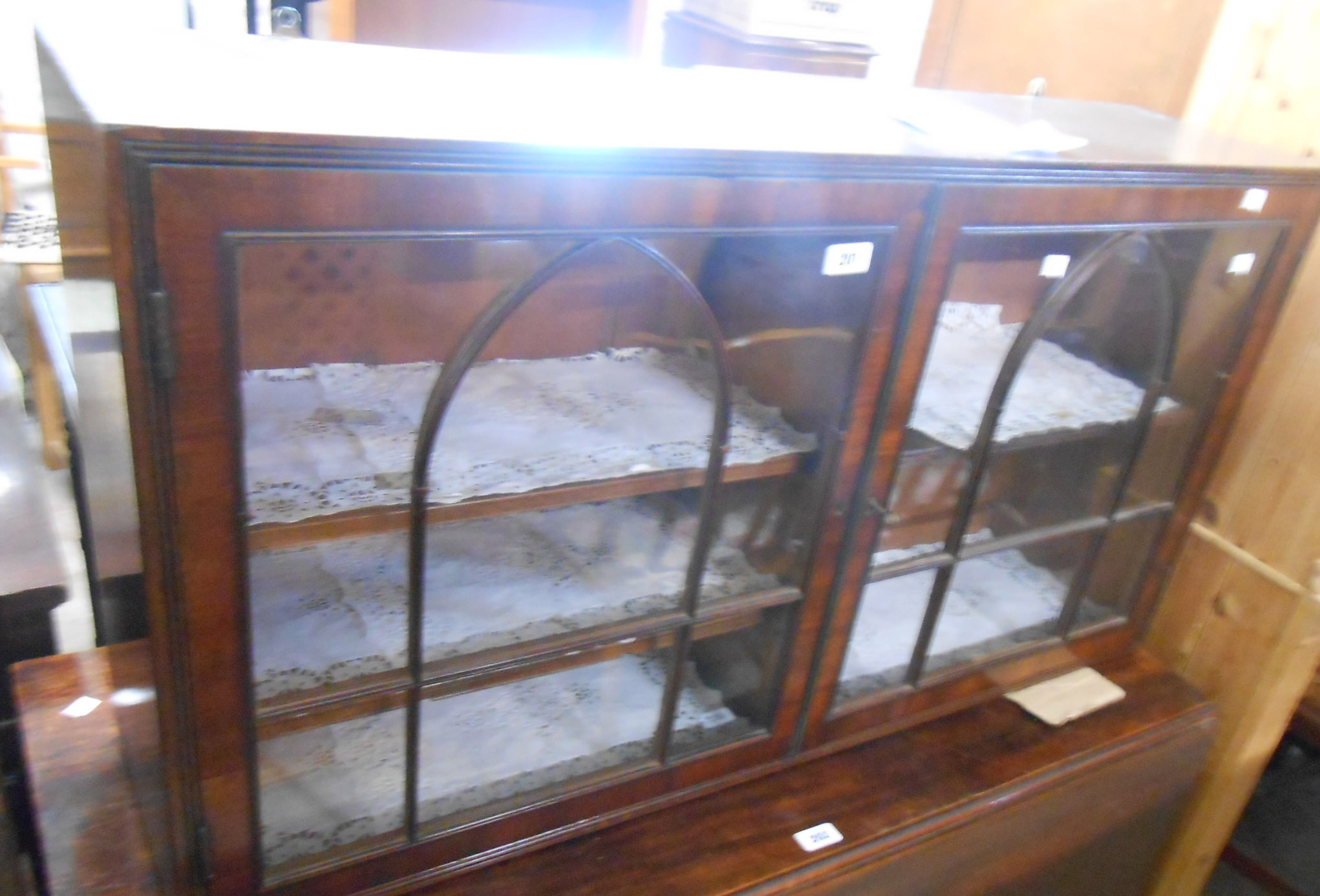 A 1.08m late Georgian mahogany wall hanging cabinet with shelves enclosed by a pair of Gothic arch