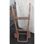 A small old sack truck with wooden frame, wrought iron bracket and cast iron wheels